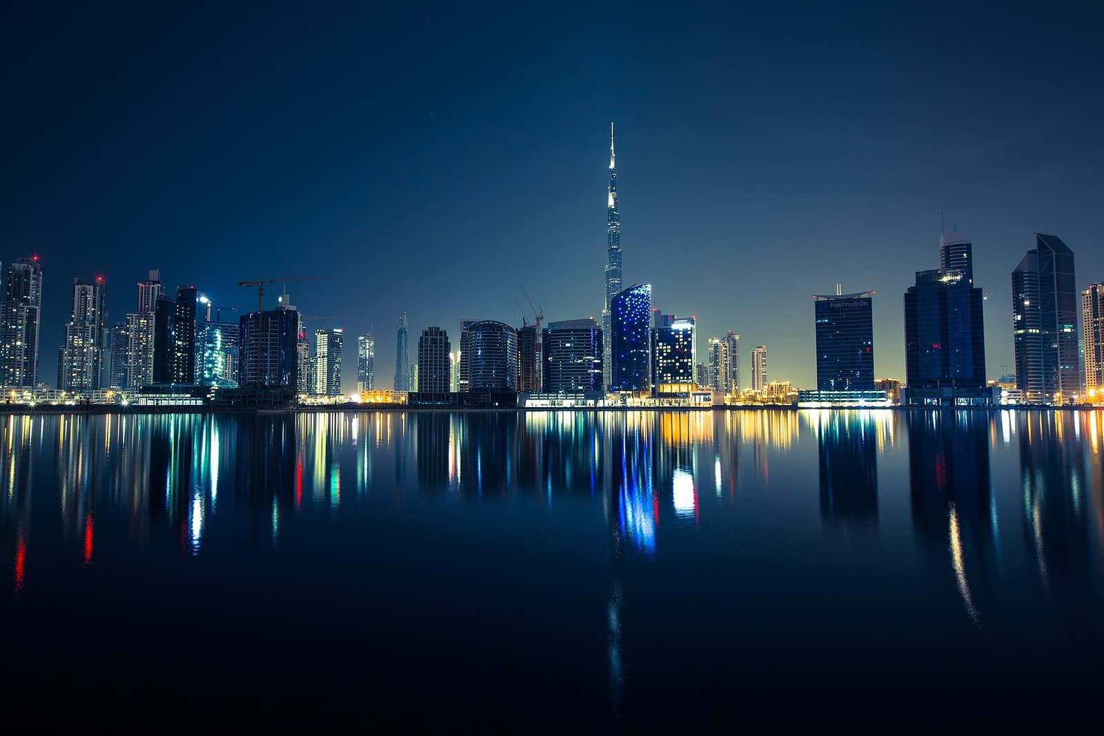 Dubai night skyline with the Burj Khalifa reflected in water, Dubai international tour package